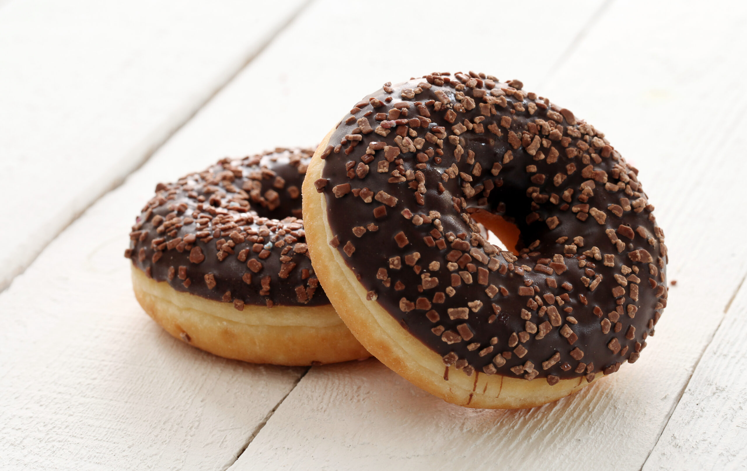 Fresh tasty donuts with glaze on a white table